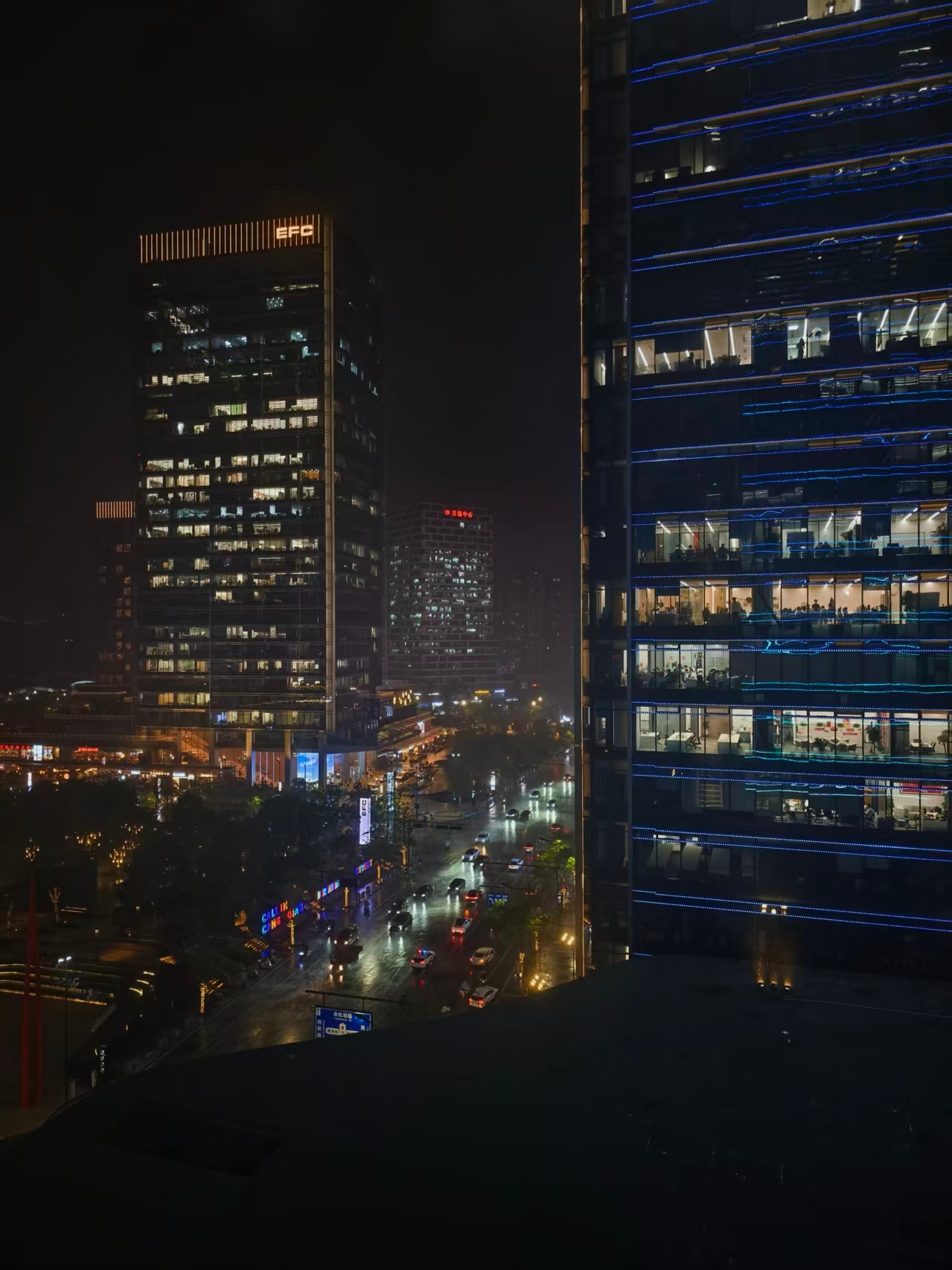 杭州夜里的大暴雨，楼宇和街道都被雨水打亮了。